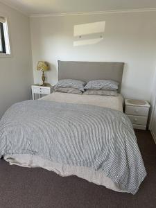 a bedroom with a bed with a striped comforter at Lovely Wanaka Crib in Wanaka