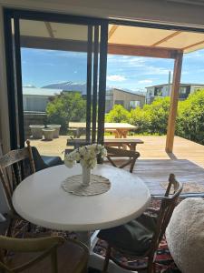 a table with a vase of flowers on a patio at Lovely Wanaka Crib in Wanaka