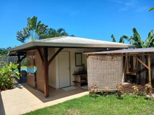 una pequeña casa con una puerta y un cobertizo en Vaiava Lodge, en Punaauia