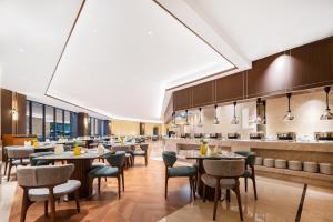 a restaurant with tables and chairs and a bar at Boao Holliyard hotel in Qionghai