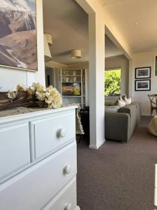 a living room with a white dresser and a couch at Lovely Wanaka Crib in Wanaka +9 photos