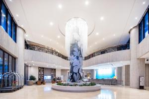 a lobby with a large chandelier in the center at Boao Holliyard hotel in Qionghai +26 photos