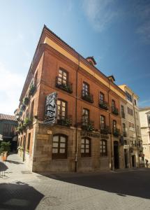un edificio de ladrillo con un cartel en el costado en Hotel La Posada Regia, en León