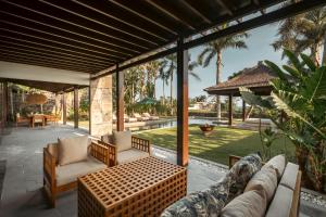 a patio with a couch and chairs and a table at Oceanfront Luxury Villa in Beraban with Private Pool in Krambitan