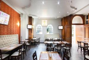 a restaurant with tables and chairs in a room at Hotel MX congreso CDMX, Trademark Collection by Wyndham in Mexico City