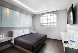 a bedroom with a large bed and a television at Hotel MX congreso CDMX, Trademark Collection by Wyndham in Mexico City