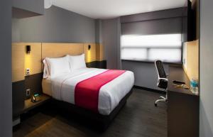 a hotel room with a large bed and a window at Hotel MX aeropuerto CDMX, Trademark Collection by Wyndham in Mexico City +39 photos