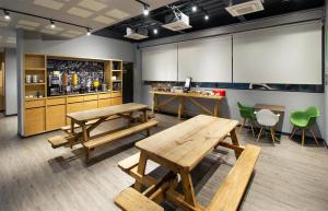 a restaurant with wooden tables and green chairs at Hotel MX aeropuerto CDMX, Trademark Collection by Wyndham in Mexico City