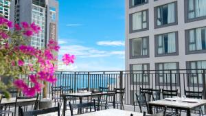 a balcony with tables and chairs on a building at Prague Nha Trang Hotel in Nha Trang