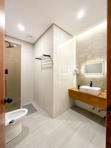 a white bathroom with a sink and a toilet at Sakuya Villa 