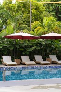 a group of chairs and umbrellas next to a pool at Sakuya Villa 