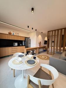 a living room with a white table and chairs at Essence Beira mar - Porto de pedras A104 in Pôrto de Pedras +22 photos