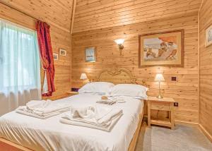 ファーナムにあるTilford Woods Lodge Retreatの木製の部屋にベッド1台が備わるベッドルーム1室があります。