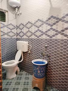 ein Badezimmer mit einer Toilette und einem Eimer darin in der Unterkunft Harvest Hill View Cottage in Udagamandalam + 16 Fotos