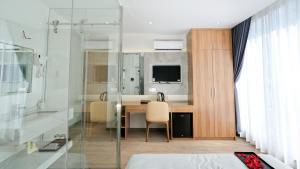 a bathroom with a desk and a television in a room at Prague Nha Trang Hotel in Nha Trang