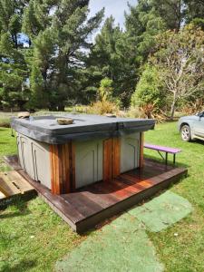 a dog house sitting on a deck in the grass at Danseys Pass Lavender Farm Retreat in Tokarahi +5 photos