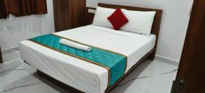 a bed in a room with a red pillow on it at Keerthis Comforts Bengaluru Airport Hotel in Bengaluru