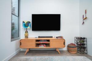 ein Wohnzimmer mit einem Fernseher an einer weißen Wand in der Unterkunft The Blue Door Heritage 2BR Cottage in CBD in Adelaide