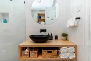 ein Badezimmer mit einem schwarzen Waschbecken und einem Spiegel in der Unterkunft The Blue Door Heritage 2BR Cottage in CBD in Adelaide
