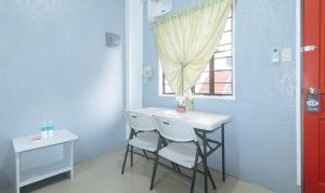 a small table and chairs in a room with a window at RedDoorz Plus near Tambo Paranaque in Manila
