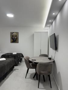 a room with a table and chairs and a tv at Apartmani Zabjelo in Podgorica +4 photos