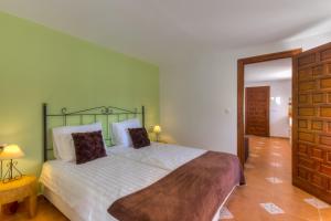 a bedroom with a large bed with a green headboard at Villa Damara in Albox +24 photos