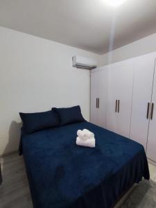 een slaapkamer met een blauw bed met een handdoek erop bij Apartamento aconchegante in Balneário Camboriú