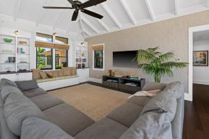 a living room with a couch and a flat screen tv at Luxury 6BR Ocean View Estate Home in Kukuiula in Kukuiula