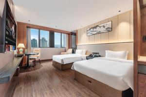 a hotel room with two beds and a desk at Chongqing Meichen Hotel Auto Expo Branch in Chongqing
