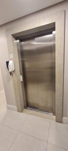 een metalen deur in een kamer met een toiletpapierdispenser bij Apartamento aconchegante in Balneário Camboriú +5 foto's