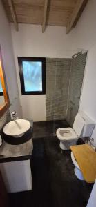 a bathroom with a toilet and a sink at La Casita del Monte in San Miguel del Monte