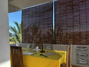 a table with a yellow table cloth on top of it at Appartement Melissa97- Bât4 Spacieux à Dzamandzar in Nosy Be