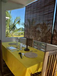 a dining table with a yellow tablecloth on a yellow table at Appartement Melissa97- Bât4 Spacieux à Dzamandzar in Nosy Be +20 photos