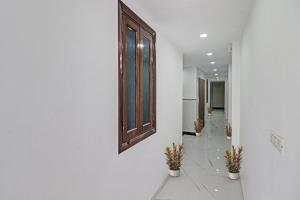 a hallway with potted plants and a mirror on a wall at SPOT ON Hotel Deluxe in Pune