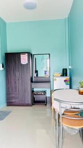 een eetkamer met een tafel en een keuken bij เอ็นแอนด์พี รีสอร์ทบุรีรัมย์ in Ban Don Wai