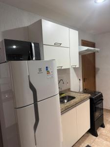 une cuisine avec un réfrigérateur blanc et un évier dans l'établissement Apartamento aconchegante na Praia de Piratininga em Niterói, à Niterói 10 autres photos