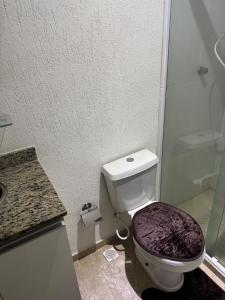 une salle de bains avec toilettes et douche en verre dans l'établissement Apartamento aconchegante na Praia de Piratininga em Niterói, à Niterói