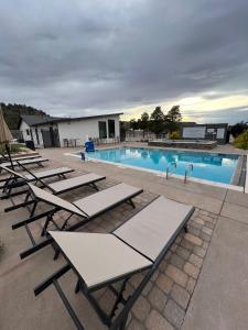 a row of lounge chairs next to a swimming pool at Tiny Home Lodge Near Zion National Park Breathtaking Views in Apple Valley