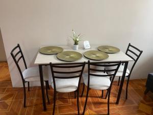 a table with four green plates on top of it at Residencia Lolita, tu hogar en Loja in Loja