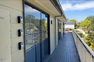 a balcony with blue doors on a building at Smart Suites Self Check-in Apartments - Freney Park Disk Golf Course in Brisbane