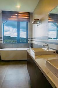 a bathroom with a tub and a sink and a window at Villa Măng Lin Đà Lạt in Da Lat