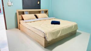 een bed met een houten frame in een kamer bij เอ็นแอนด์พี รีสอร์ทบุรีรัมย์ in Ban Don Wai