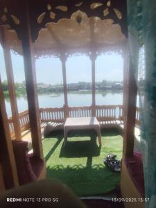 a gazebo with a bench in front of a river at Young Lake Palace Group Of Houseboats in Srinagar