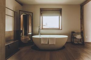 a bathroom with a large tub and a window at tsingpu retreat in Baisha