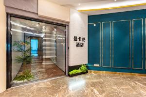 広州市にあるMankalun Hotelの青い壁とガラスのドアのあるロビー