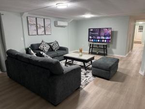 a living room with two couches and a flat screen tv at The Blue Oasis - Palm & Pool Retreat in Pearland