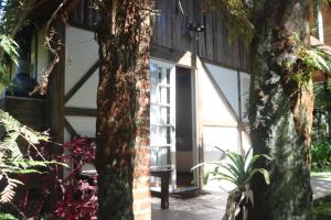 a front door of a house with a tree at A Cabana Chalé & Pousada - Especializada em Grupos até 40 Pax- in Canela
