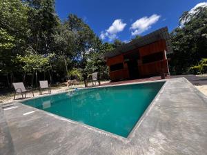 a swimming pool with a house in the background at Hotel "Casa Las Lolas" in Xpujil