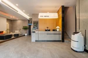 広州市にあるMankalun Hotelのロビーの受付デスクに座っている男性