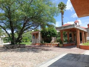 a house with a palm tree and a building at Villa Colibri in Tequisquiapan